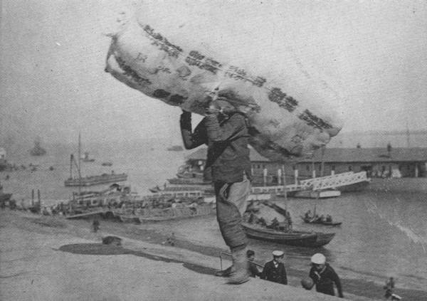 EARNING HIS LIVING  This coolie, who carries 420-lb. bale of cotton, as seen in the picture, from the ship in the river to the Hankow Bund, probably earns a dollar and a half per week!