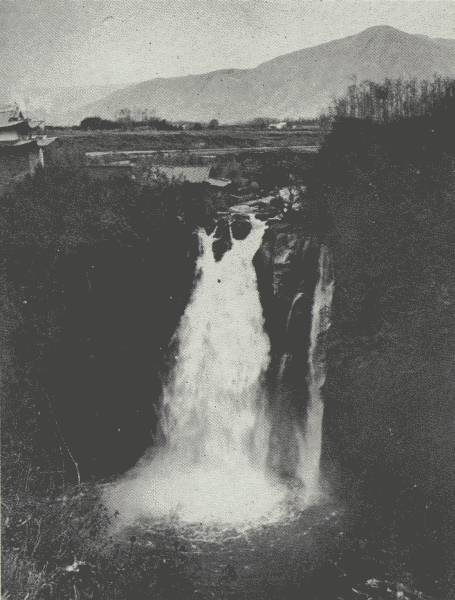 THE TENGYUEH WATERFALL  Mountains opposite are about 4,000 feet higher than the Tengyueh Plain, which is about 5,500 feet; over this waterfall one of author's ponies "committed suicide," Chinese said.