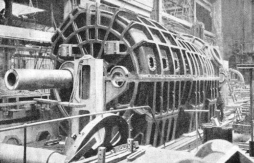 One of the low-pressure turbines of the Carmania, in casing. Its size will be inferred from comparison with the man standing near the end of the casing.