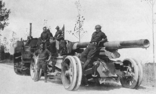 IN THE COURSE OF ITS PROGRESS TO THE VALLEY OF THE VESLE THIS 155 MM. GUN AND OTHERS OF ITS KIND WERE EDUCATING THE BOCHE TO RESPECT AMERICA. THE TRACTOR HAULS IT ALONG STEADILY AND SLOWLY, LIKE A STEAM ROLLER