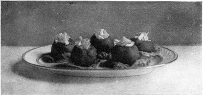 TOMATOES STUFFED WITH CELERY AND MAYONNAISE STANDING ON LETTUCE LEAVES.