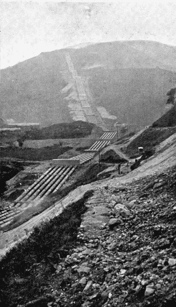 By permission of the British Aluminium Co  A Striking Feature of Modern Aluminium Works  For the production of aluminium water power is required. Water is stored at a high level and is then brought down to the factory in pipes. The illustration shows the pipe track recently laid down for this purpose at Kinlochleven in Argyleshire. The six pipes, each of which is thirty-nine inches in diameter, run down the hillsides for one mile and a quarter