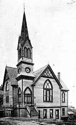 Two story frame building with gables, light colored building with distinctive dark trim.