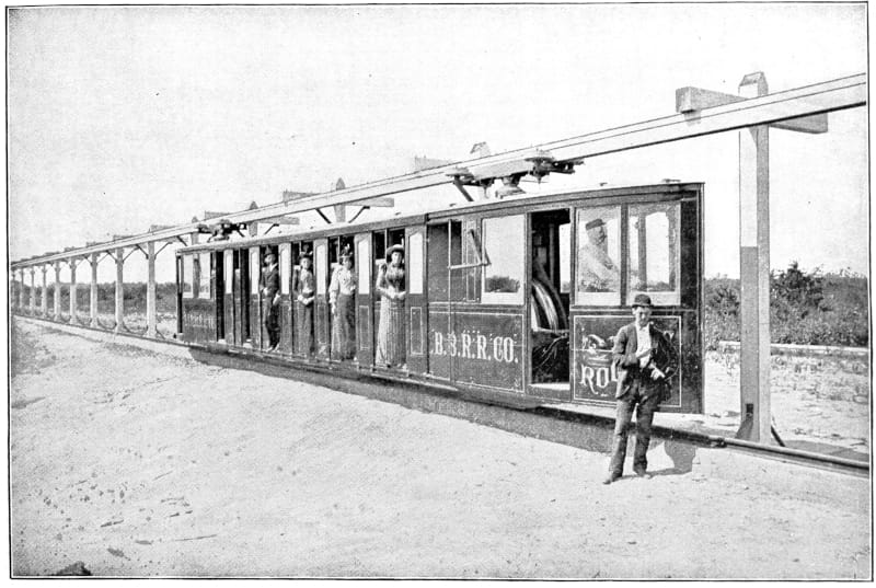 A man standing by a bicycle electric car with passengers.