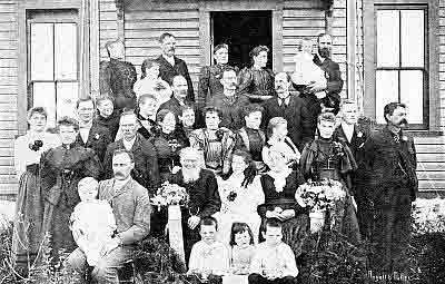 Family in Sunday best on front porch steps.